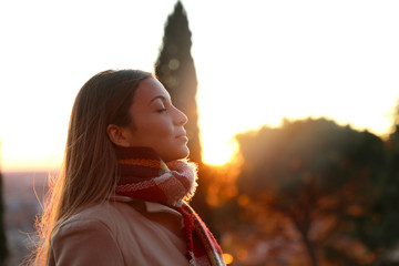 Portrait of a girl breathing fresh air wearing jacket at sunset