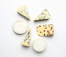 Assortment of fresh cheeses on white background