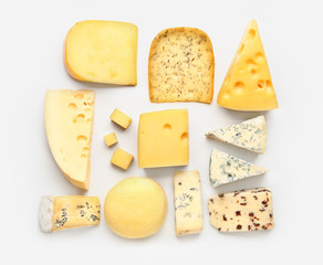 Assortment of fresh cheeses on white background
