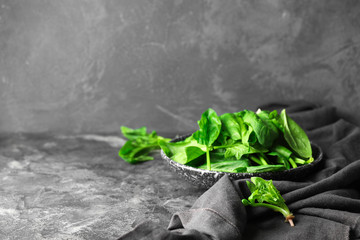 Plate with fresh green spinach on table