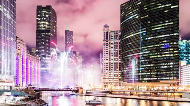 Fireworks display celebration along the Chicago River at Wolf Point in Chicago, Illinois. Time lapse cityscape at night.