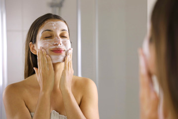 Skincare woman washing face  foaming soap scrubbing skin. Face wash exfoliation scrub soap woman...