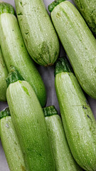 Green zucchini courgettes in a grocery store, closeup, background
