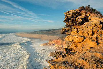 rock and beach with waves on the shores of the Atlantic Ocean near the town of Nazare in Portugal...