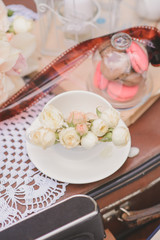 Delicate roses in a white porcelain Cup on a saucer in the decor of a wedding or birthday