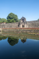 Obraz premium Fort Santiago Entrance Archway With Still Moat River In Front and Spanish Stone Carving Design in Intramuros, Manila, Philippines