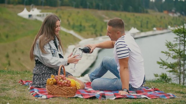 couple on a picnic drink wine