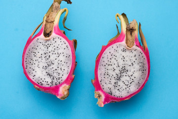 Two Exotic dragon fruit on blue background, macro. Sweet juicy tropical fruit surface.