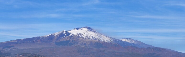 Fototapeta na wymiar Etna volcano covered in snow. View from afar. Italy