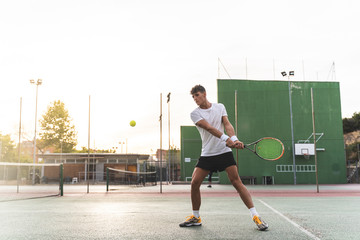 Young Man Playing Tennis Outdoors.