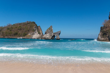 Fototapeta premium Atuh Beach With Famouse Rock Island Outcrop and Natural Arch Carved By The Bright Turquoise Ocean on Nusa Penida, Bali, Indonesia