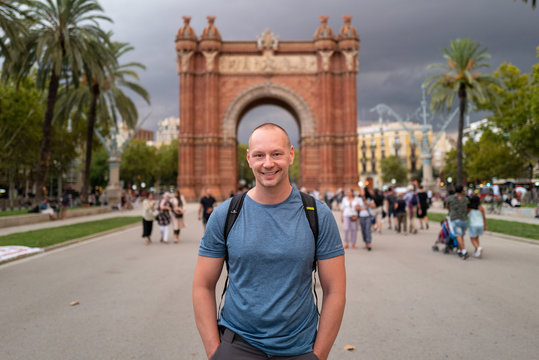 Man smiling in Barcelona in front of arc