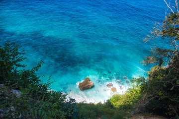 Suwehan Beach With Famous Limestone Rock Tor or Island Landmark In Bright Turquoise Water on Nusa Penida, Bali, Indonesia From Above