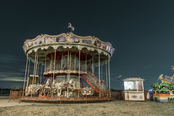 Carousel against the night sky. Vintage carousel with horses at night