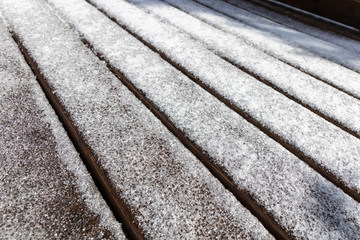 Selective focus of snow covering wooden deck