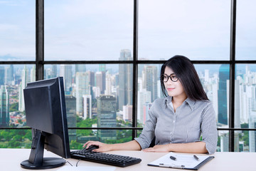 Asian businesswoman working on her desktop happily