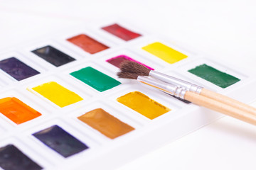 Watercolor art paint with brushes. A palette of multi-colored paints for drawing with water. on white background