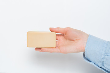 Rectangular bar of soap on a female palm. Isolated on a white background. Copy space