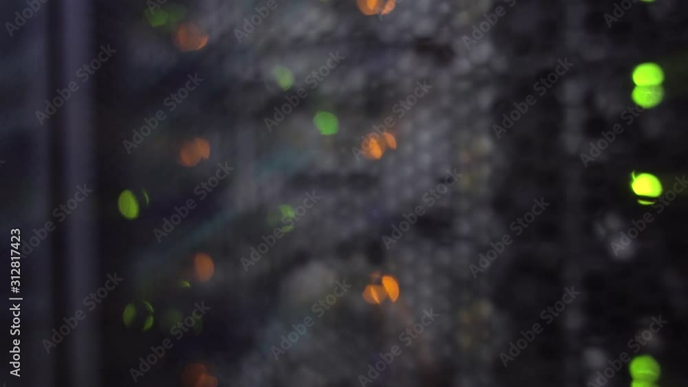 Poster green and orange bokeh led lights blinking on back side of working data server.