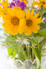 Bouquet of yellow flowers on the blurred background. Chamomile, golden daisy and chrysanthemum close-up. Greeting card template with blooming flowers. Summer time. Selective focus.