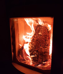 Holzscheit brent im Kaminofen höllenheiß