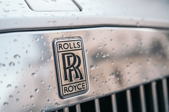 LONDON, UNITED KINGDOM - January 02, 2020: A close-up of the Rolls Royce logo on a grey car with drops of water. Rolls Royce remains a symbol of a luxurious car.