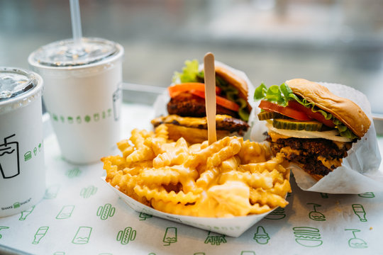LONDON, UNITED KINGDOM - January 02, 2020: Shake Shack Hamburger in London city. Double cheeseburger with tomato lettuce and onion, Cheese Fries and Milkshake.