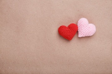 Valentine's day decorative background. Two handmade crochet hearts on craft paper. Flat lay, top view, copy space