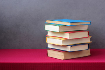 stack of books in colored hard covers on the table.
