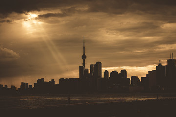 Naklejka premium A high-contrast view of the Toronto skyline with a dramatic sky covered in clouds, Toronto, Ontario, Canada
