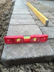 Block paving driveway under construction with spirit levels 