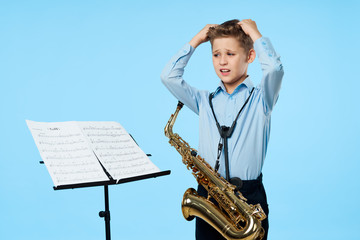 Fototapeta premium young boy with a saxophone