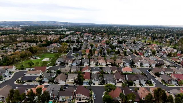 Aerial view of urban sprawl. Suburban packed homes neighborhood with road. Vast subdivision in Irvine, California, USA