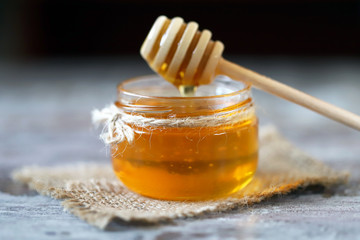 Selective focus. Jar of honey. Stick for honey.