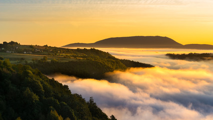 Cloud inversion above hills during colorful sunrise 