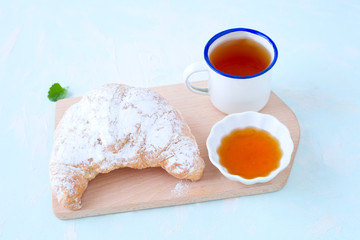 Croissant mit Honig und Tee