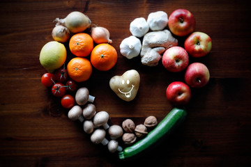 Herzförmige Kartoffel mit lachendem Gesicht, Obst und Gemüse aus biologischen Anbau.