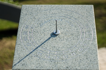 Sundial on a city street. The inscription in Russian on a stone is a solar watch. - obrazy, fototapety, plakaty