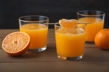 Fresh tangerine juice on a brown wooden table