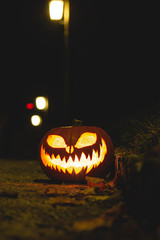 Halloween pumpkin in corner of road at night