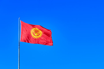 Kyrgyzstan flag waving on the wind against the blue sky