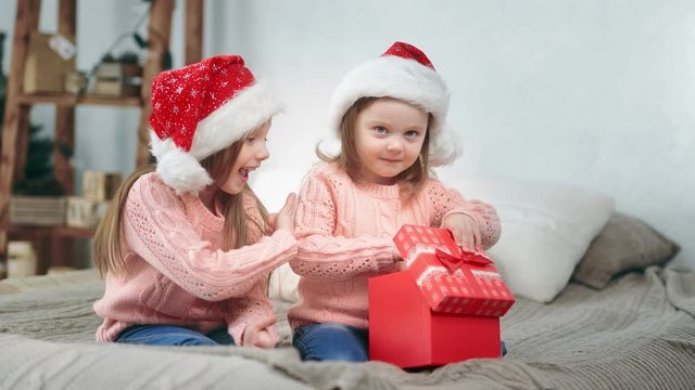 Cheerful baby sister laughing celebrate december holiday open fairytail present feeling exciting