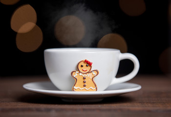 Cup of coffee and cookies on a table with fairy lights
