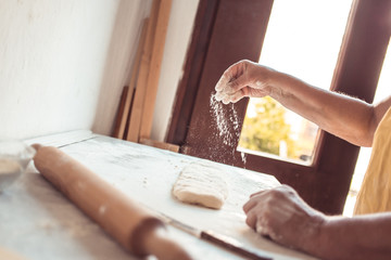 Female hands flouring surface. Process of making croissant rolls