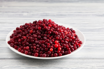 Photo of a plate topped with cranberries. Copy space.