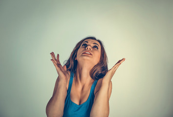 Furious stressed woman screaming looking up.