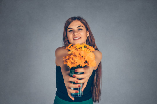 Woman Giving Wreath Of Yellow Flowers Looking To You Camera.