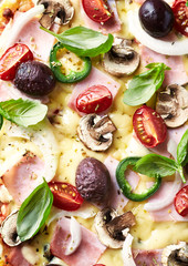 Pizza with ham, cheese, cherry tomatoes, jalapeno pepper, kalamata olives, champignon mushrooms and fresh basil. Dark wooden background. Top view.