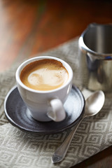 Cup of coffee on rustic wooden background.