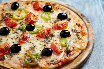 Pizza with cherry tomatoes, black olives, jalapeno pepper, capers and oregano. 